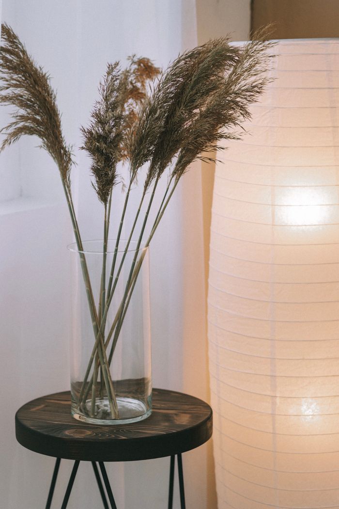 The Art of Drawing Readers In: Your attractive post title goes here Stylish minimalist home decor featuring a vase with ornamental grass and a soft lamp glow.